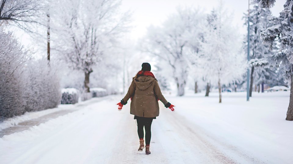 Woman walking down snowy street