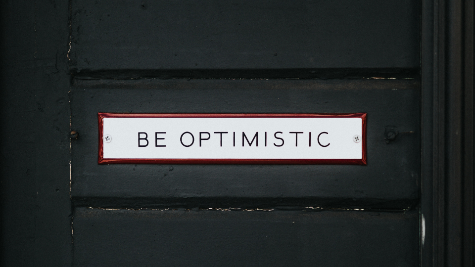 be optimistic sign on a black door