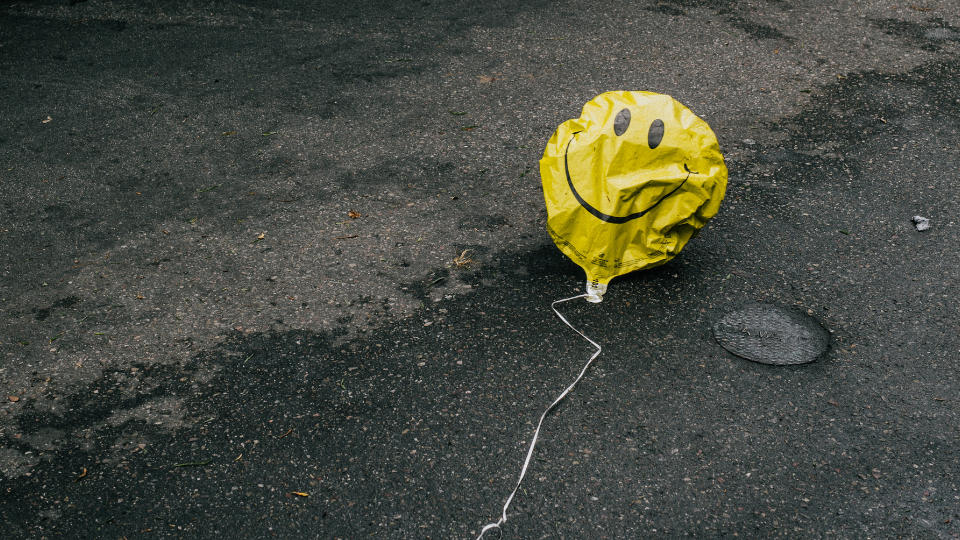 smiley face balloon laying in the street