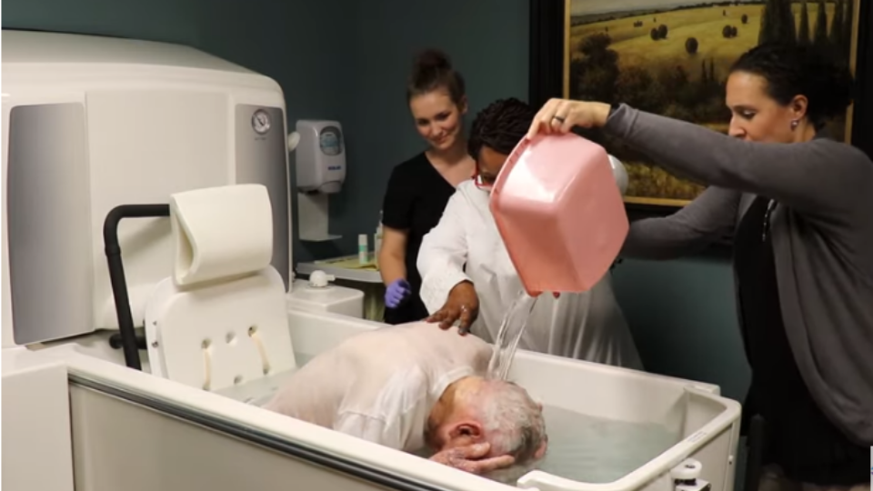 Grindstaff getting baptized in a medical tub