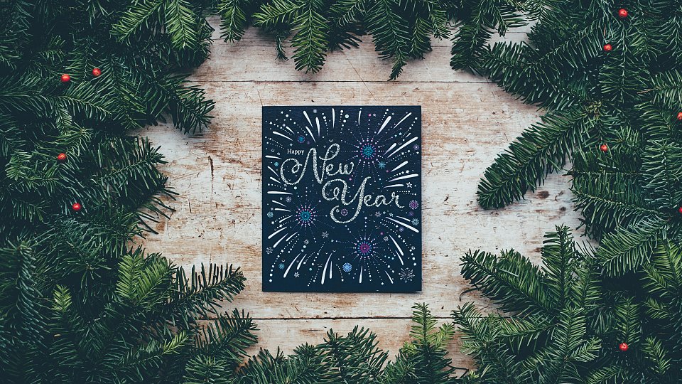 Sign saying Happy New Year surrounded by a Christmas tree