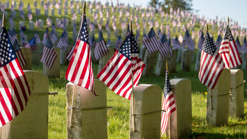 cemetary with US flags on each headstone