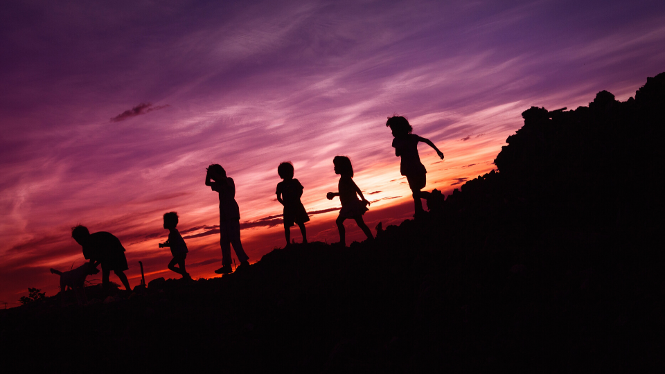 kids playing walking in a line during sunset