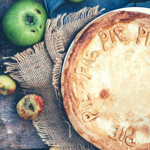 pie on kitchen table next to apples