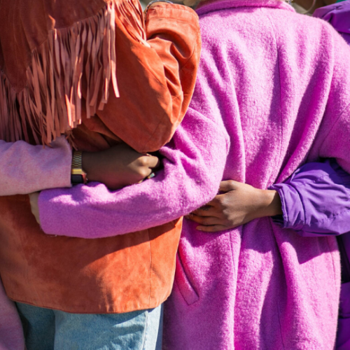 girls hugging wearing pink and purple jackets