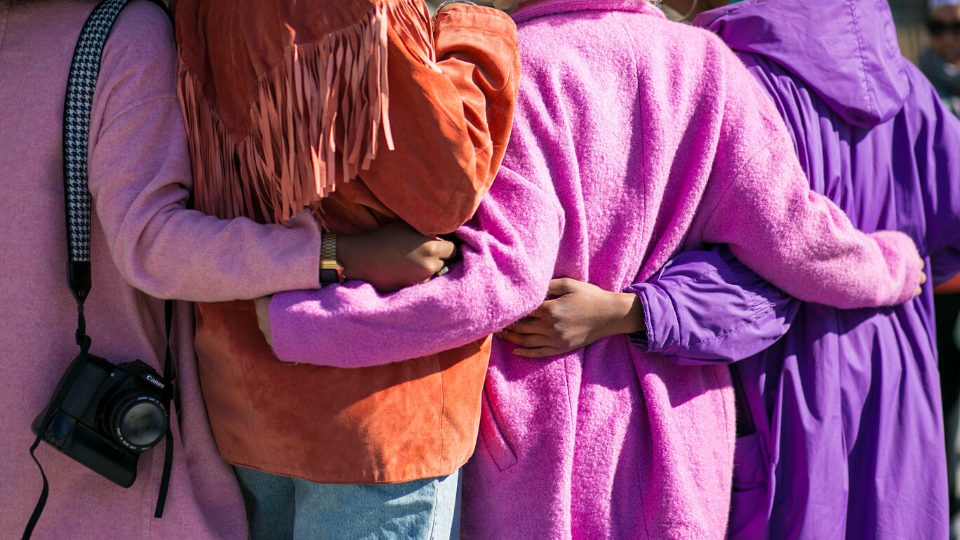 girls hugging wearing pink and purple jackets