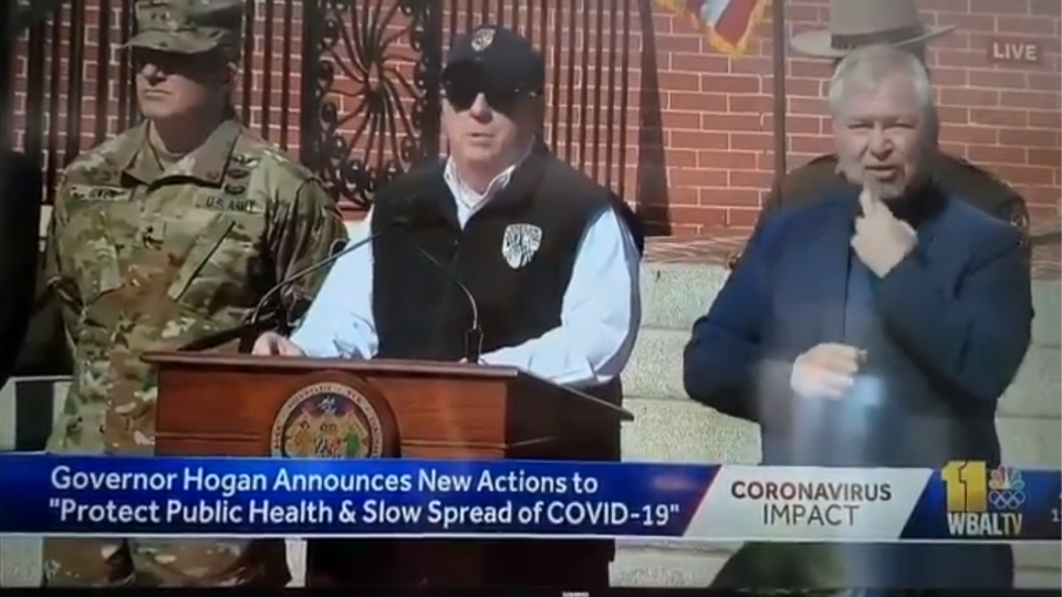 Governor Hogan standing at podium with sunglasses and a hat giving an update on the Coronavirus precautions in Maryland