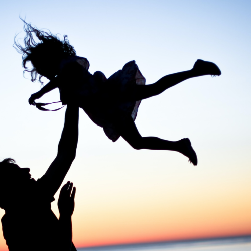 shadow silhouette of dad throwing daughter in the air