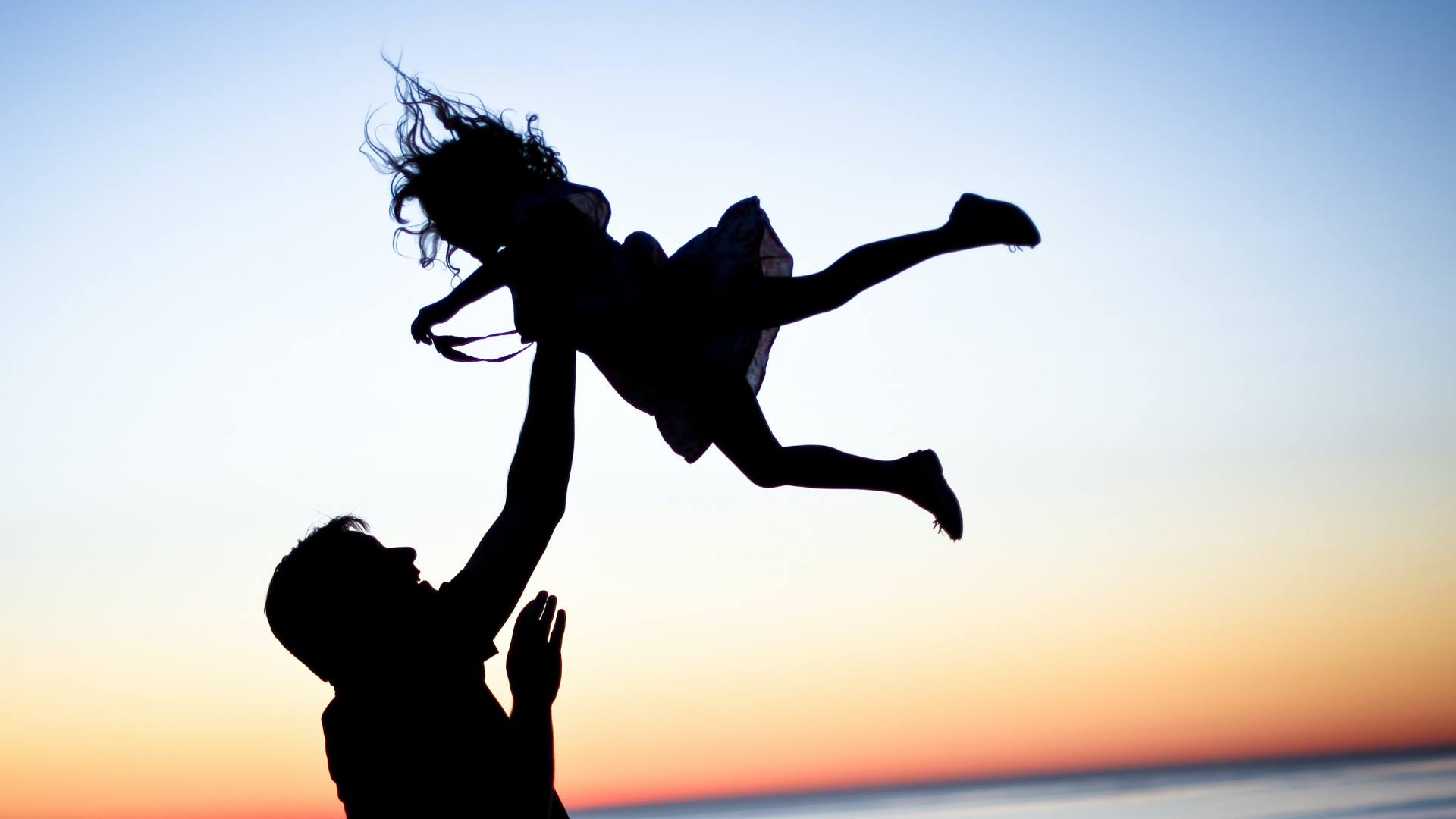 shadow silhouette of dad throwing daughter in the air
