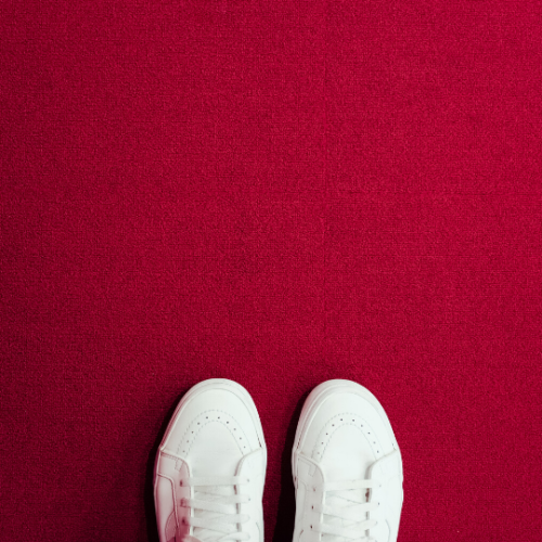 white shoes standing on a red carpet