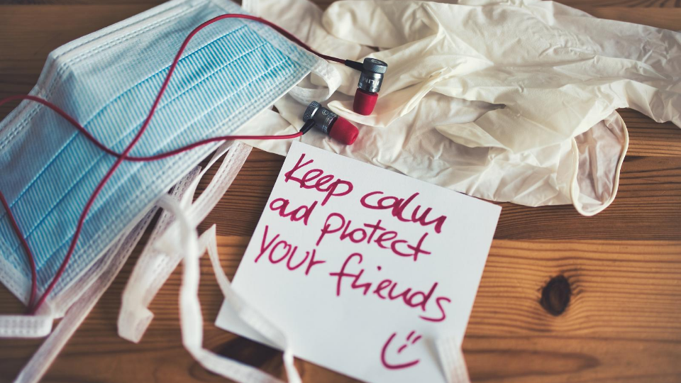 Blue mask sitting next to gloves with a note that reads Keep Calm and Protect Your Friends