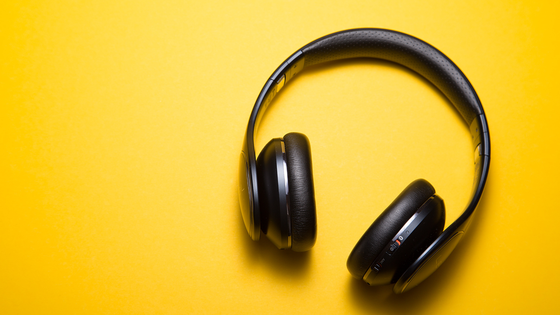 black headphones on yellow background