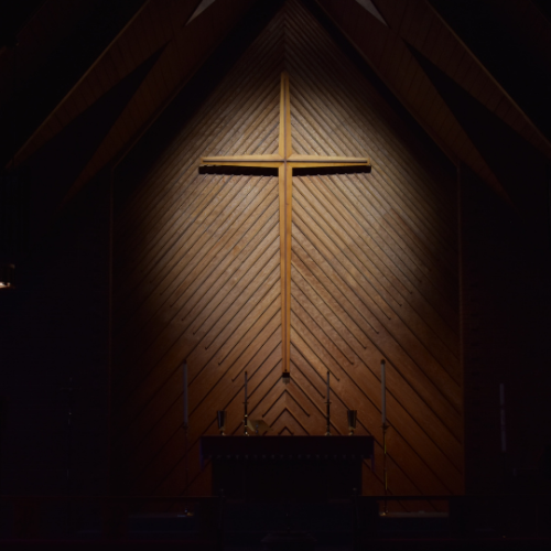spotlight on a wooden cross on a church wall
