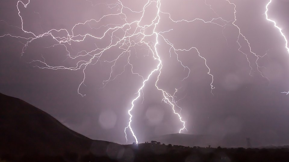 lightning bolt striking near mountain