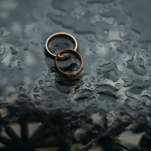 two rings laying on a glass surface in the rain