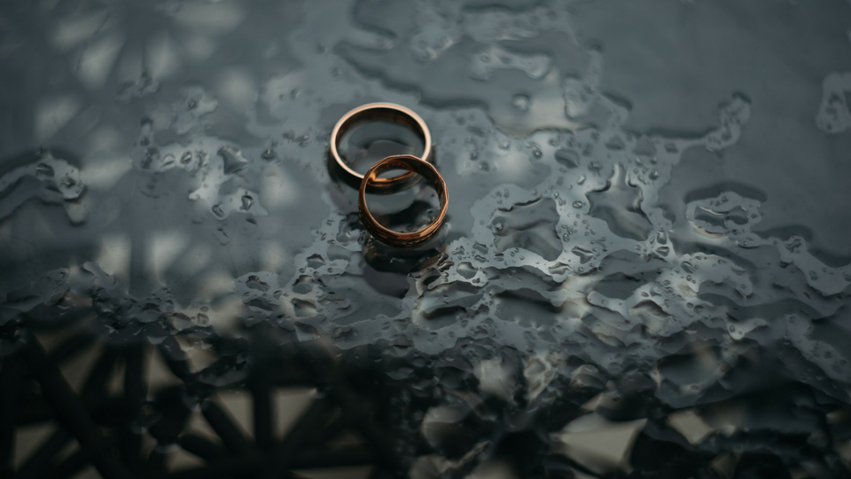 two rings laying on a glass surface in the rain