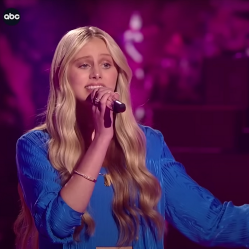 Haven Madison wearing a blue shirt while she holds a microphone and sings to the judges on American Idol