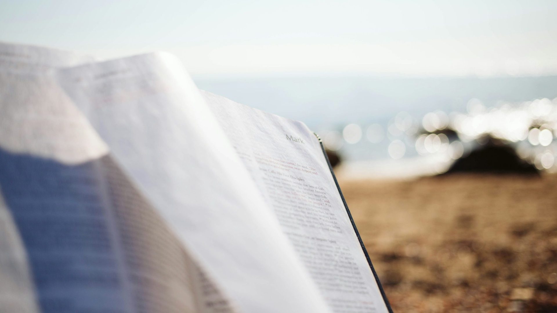 Open Bible turned to Mark beach background bright.
